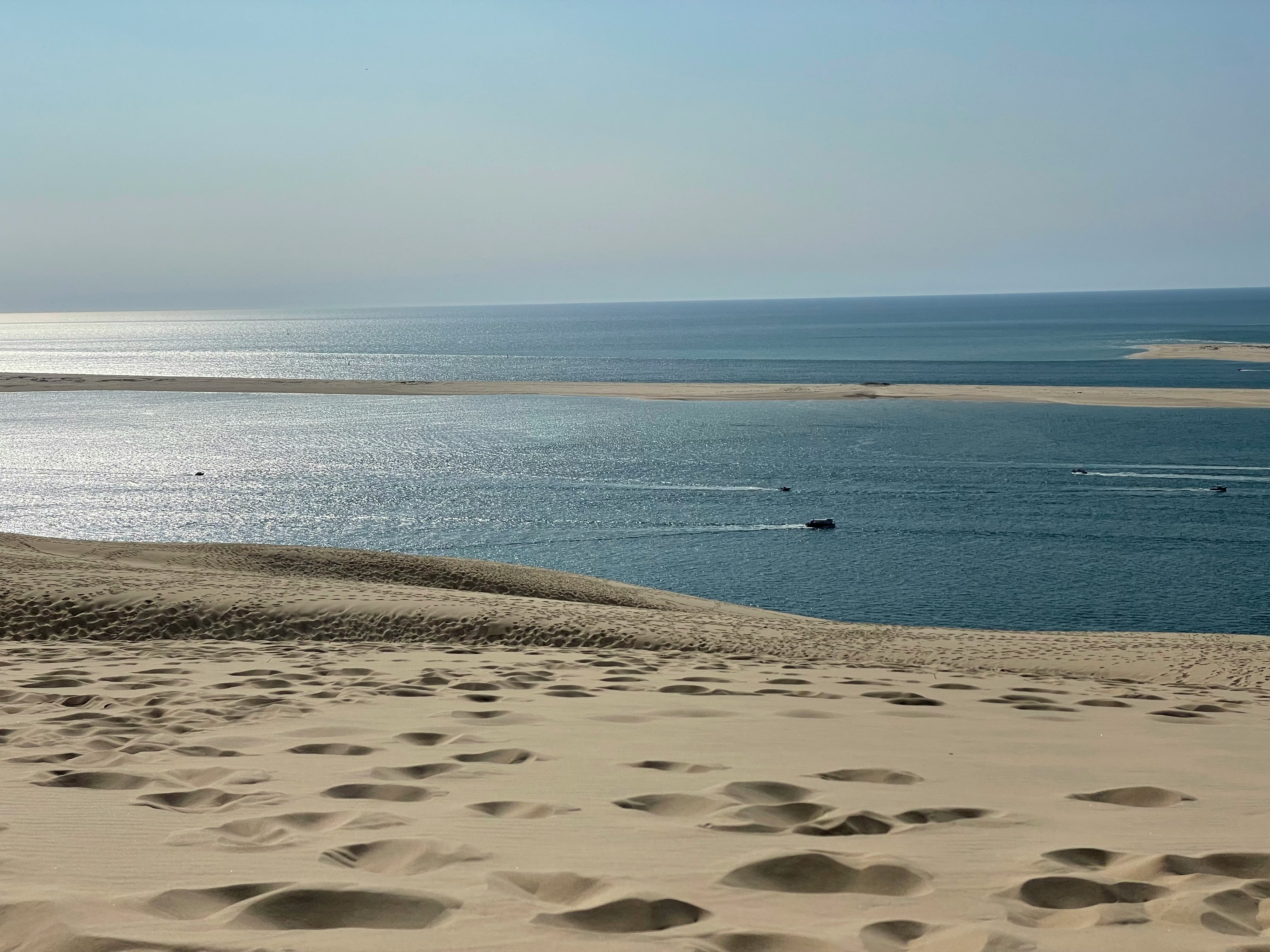 brown sand near body of water during daytime